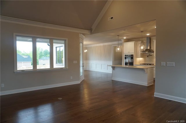 unfurnished living room featuring an inviting chandelier, high vaulted ceiling, crown molding, and dark hardwood / wood-style floors