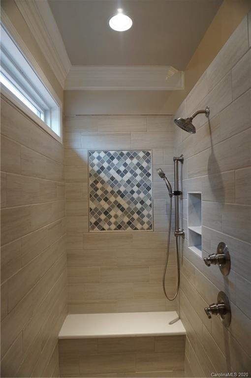 bathroom featuring ornamental molding and a tile shower