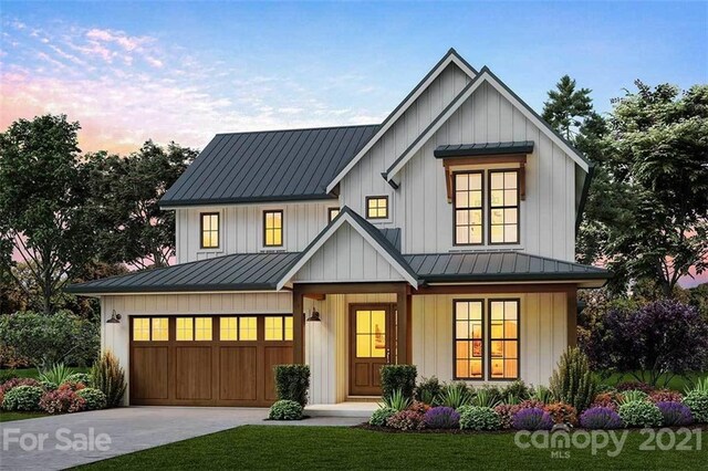 modern inspired farmhouse featuring covered porch, a yard, and a garage