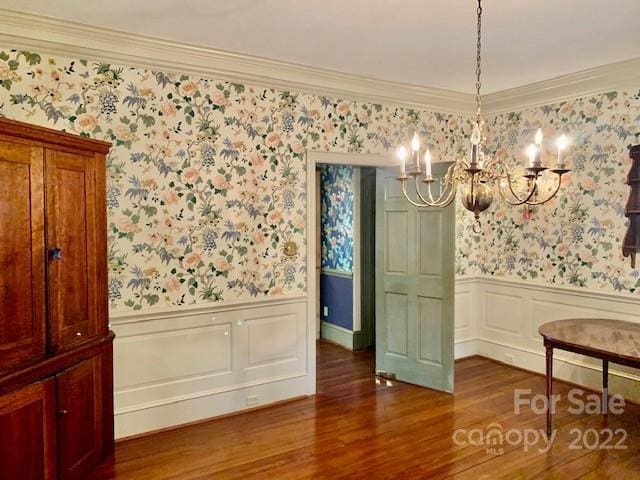 dining area featuring ornamental molding, a notable chandelier, and dark hardwood / wood-style floors