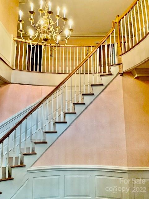 staircase featuring a towering ceiling and a chandelier