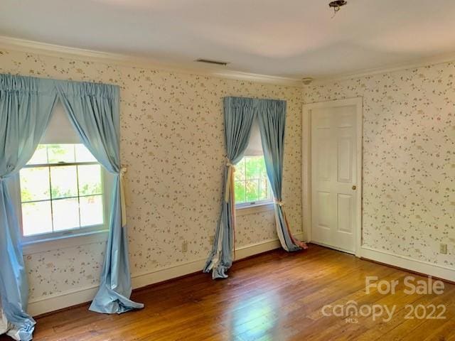 unfurnished room with hardwood / wood-style flooring and ornamental molding