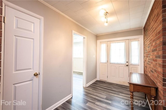 foyer with brick wall, ornamental molding, and dark hardwood / wood-style flooring