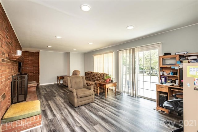 living room with crown molding, dark wood-type flooring, and a wood stove