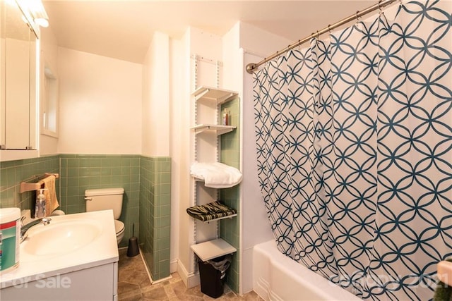 full bathroom featuring shower / tub combo with curtain, tile walls, tile floors, vanity with extensive cabinet space, and toilet