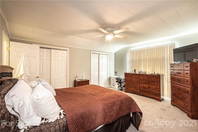 carpeted bedroom with two closets and ceiling fan