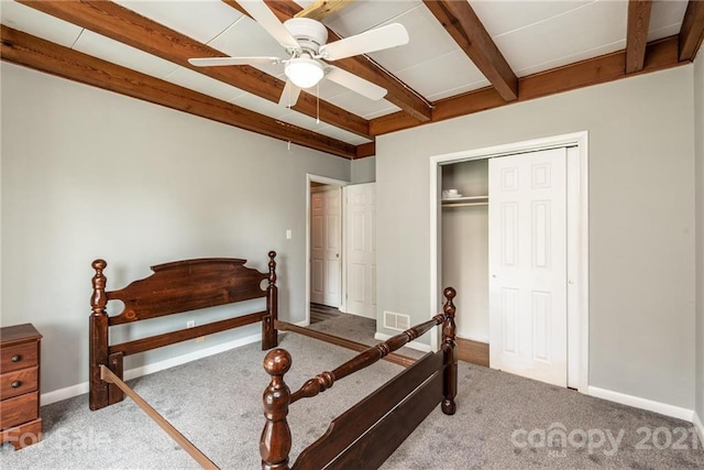 bedroom with a closet, carpet flooring, ceiling fan, and beamed ceiling