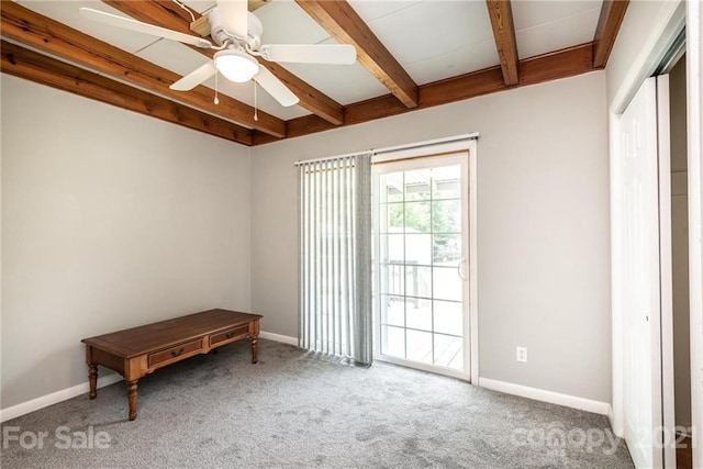 carpeted spare room with beam ceiling and ceiling fan