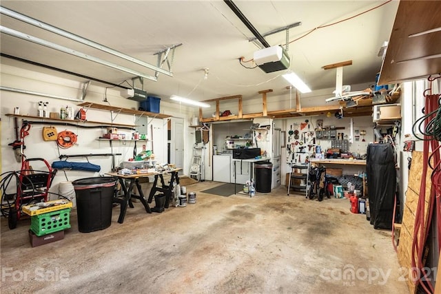 garage featuring a workshop area, washing machine and clothes dryer, and a garage door opener