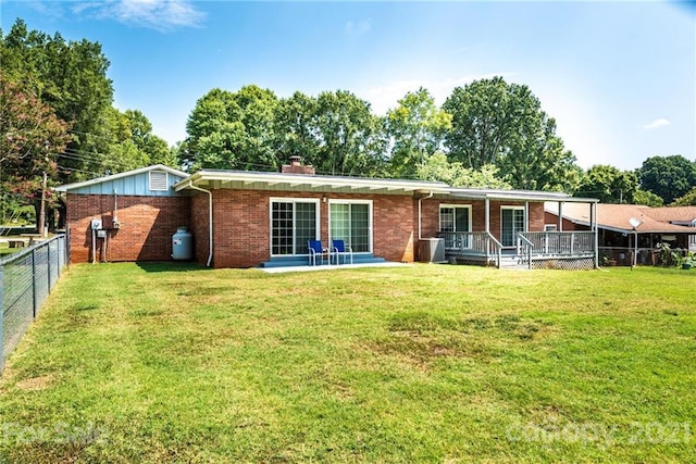 back of property featuring a yard and a patio