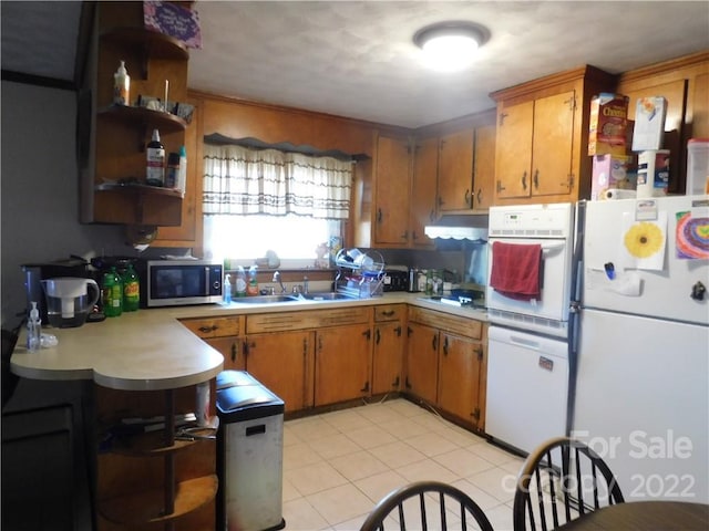 kitchen with light tile flooring, sink, and white appliances