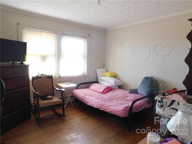 bedroom with dark hardwood / wood-style flooring and ornamental molding