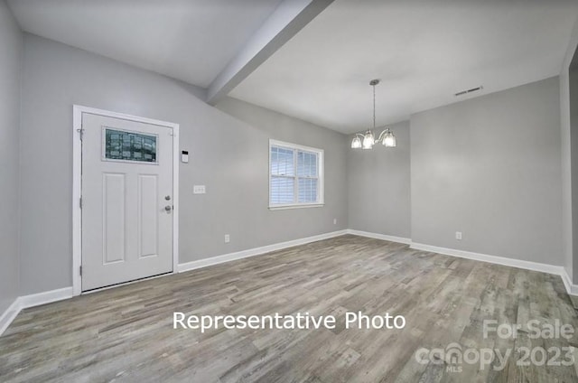 entrance foyer with light wood-type flooring and an inviting chandelier