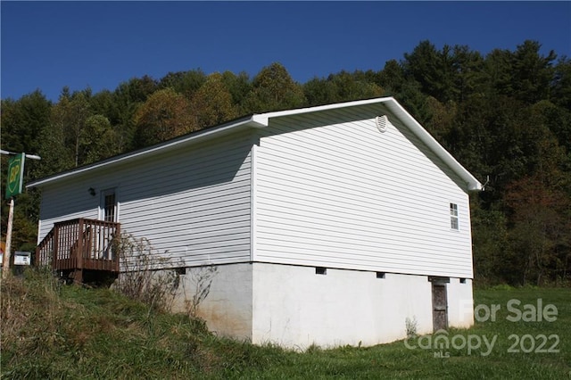 view of side of home with a wooden deck