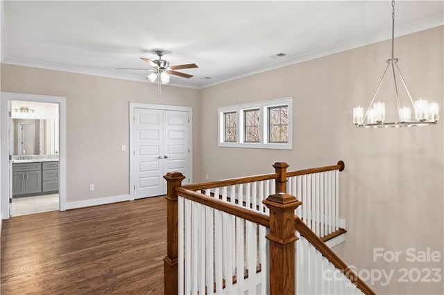 hall featuring dark hardwood / wood-style flooring, ornamental molding, and a chandelier