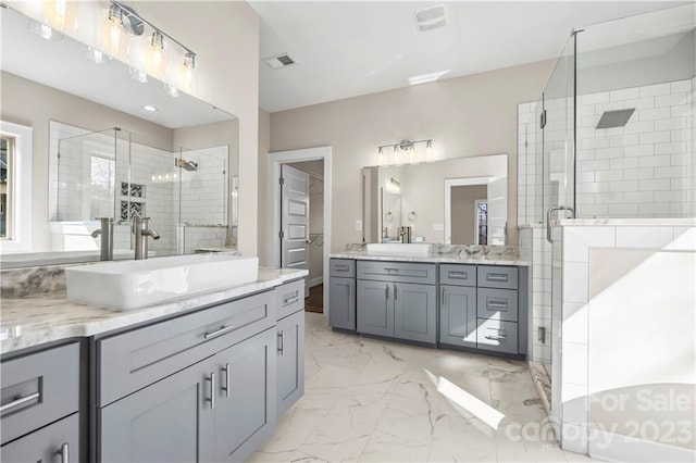 bathroom with a shower with shower door, dual sinks, large vanity, and tile floors