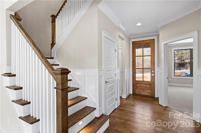 foyer with dark wood-type flooring and ornamental molding