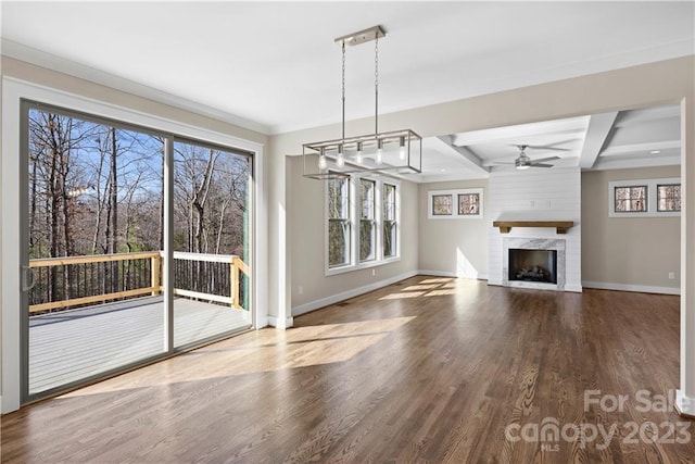 unfurnished living room with ceiling fan, dark wood-type flooring, a brick fireplace, and beamed ceiling