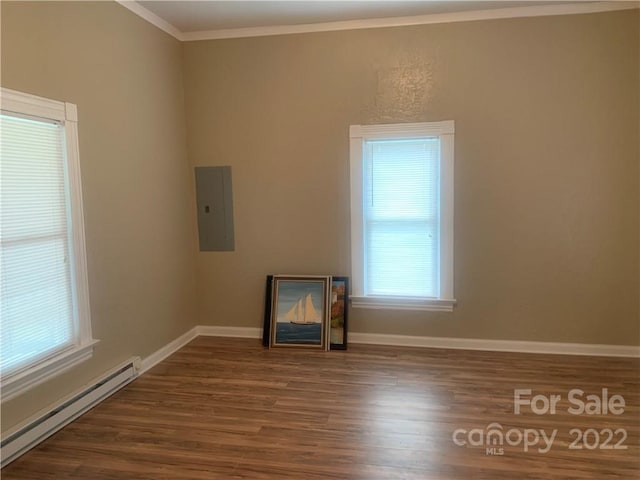 empty room featuring ornamental molding, dark wood-type flooring, and baseboard heating