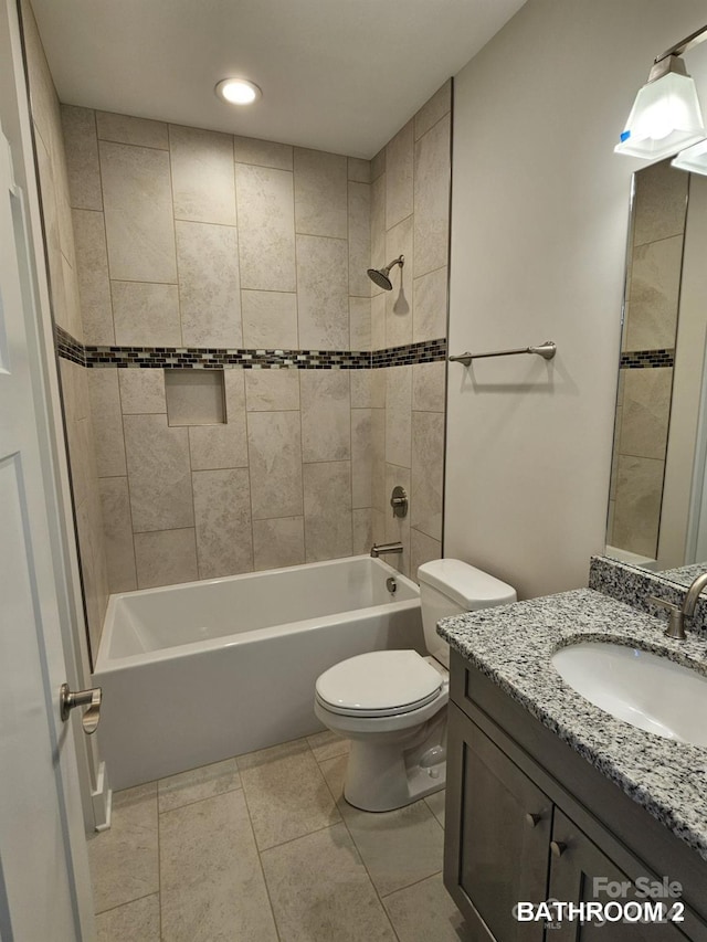 full bathroom featuring tile patterned floors, tiled shower / bath combo, vanity, and toilet