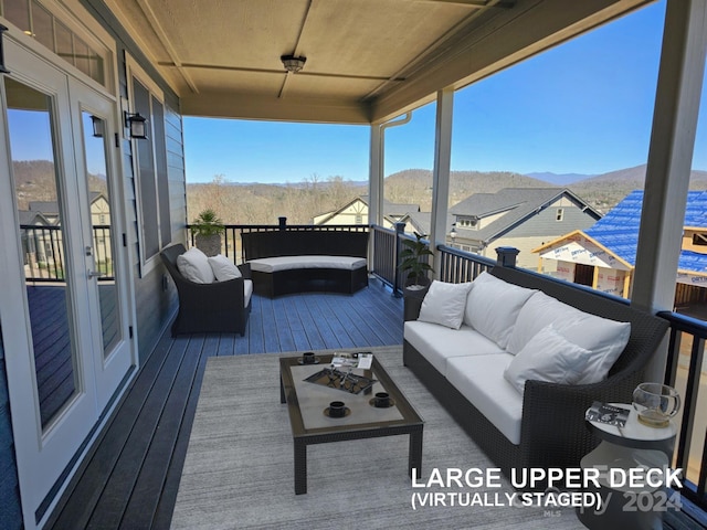 deck with french doors, a mountain view, and outdoor lounge area