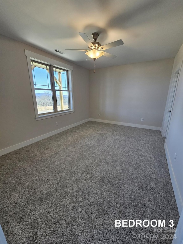 carpeted empty room featuring ceiling fan