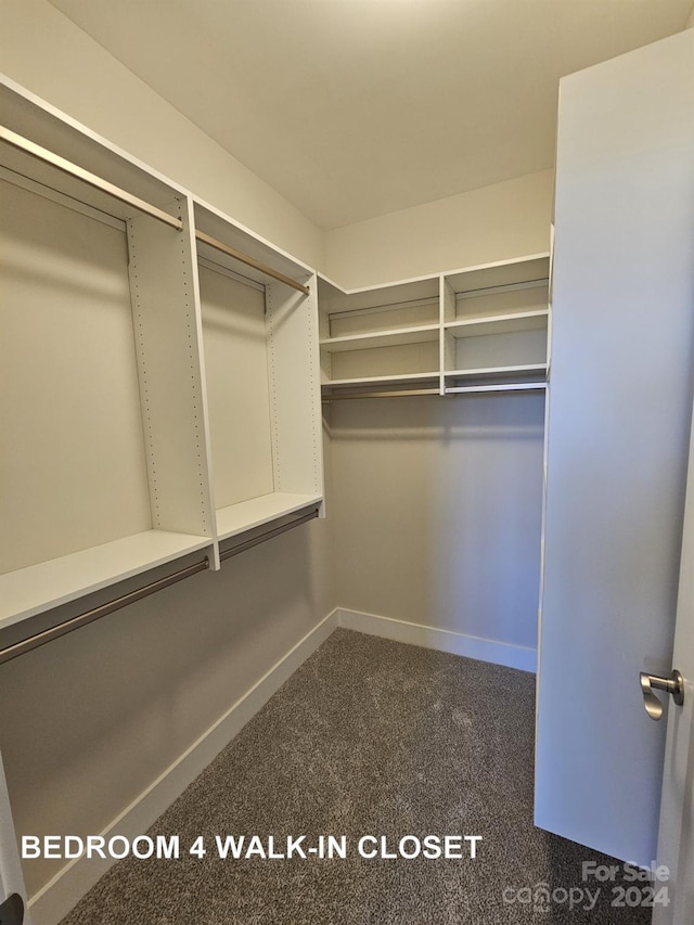 spacious closet featuring dark carpet