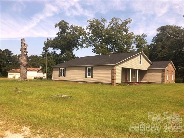 rear view of property with a yard