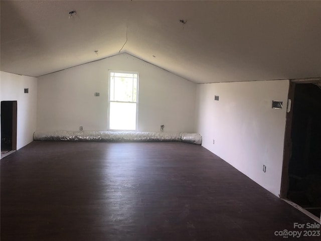 additional living space featuring lofted ceiling and dark hardwood / wood-style floors