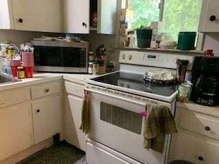 kitchen with white cabinetry and electric range