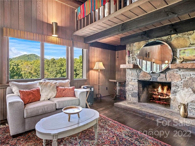 living room with wooden ceiling, dark wood-type flooring, wooden walls, and a stone fireplace