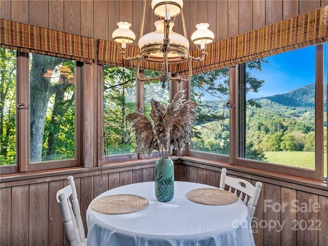 sunroom featuring an inviting chandelier and a mountain view