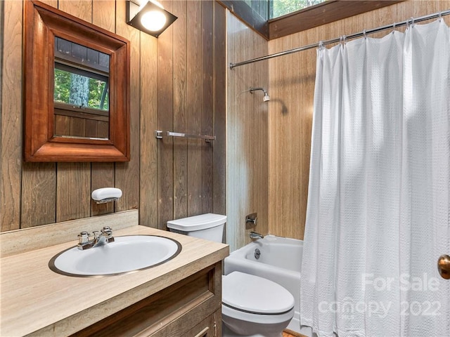 full bathroom with wooden walls, shower / bath combo with shower curtain, toilet, and vanity