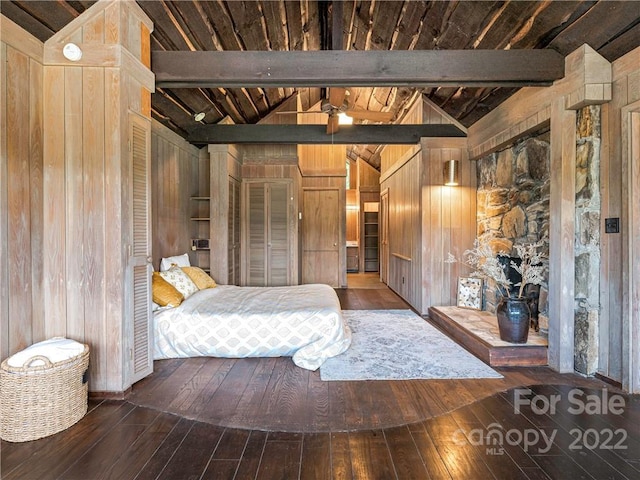 unfurnished bedroom with wooden walls, dark wood-type flooring, and beam ceiling