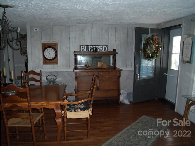 dining space with a textured ceiling and dark hardwood / wood-style flooring