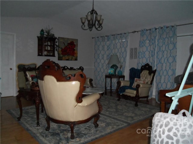 living room with a notable chandelier, lofted ceiling, and hardwood / wood-style flooring