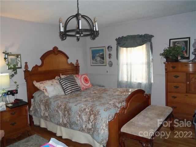 bedroom featuring an inviting chandelier and dark wood-type flooring