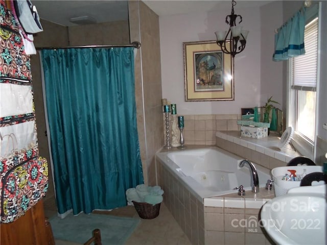 bathroom featuring a relaxing tiled bath, tile floors, and a notable chandelier