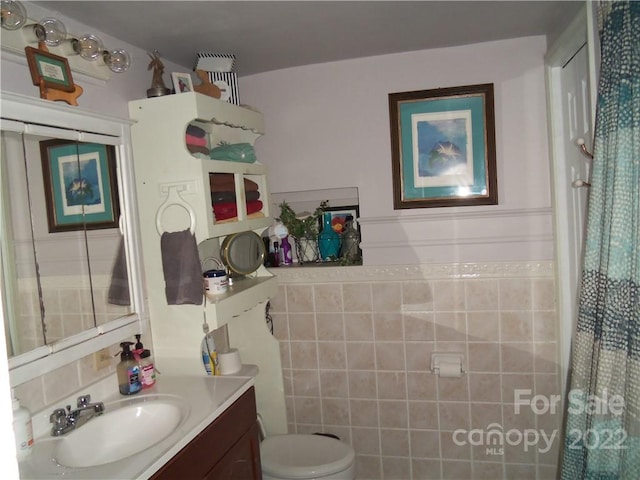 bathroom with tile walls, toilet, and oversized vanity