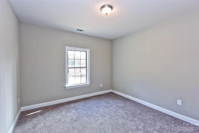 spare room with dark colored carpet