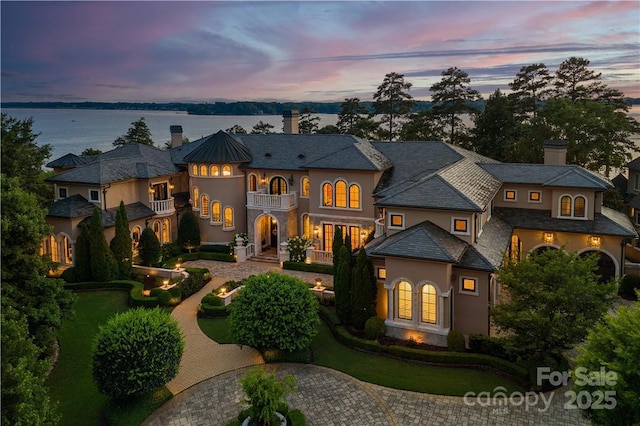 view of front of property featuring a water view and a balcony