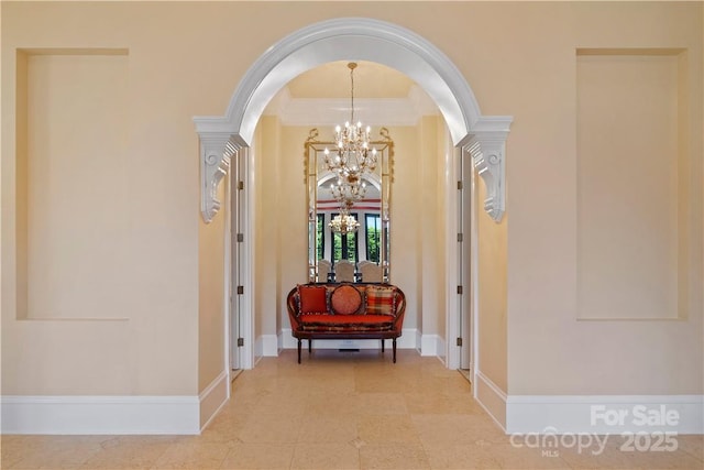 hall featuring crown molding and a notable chandelier