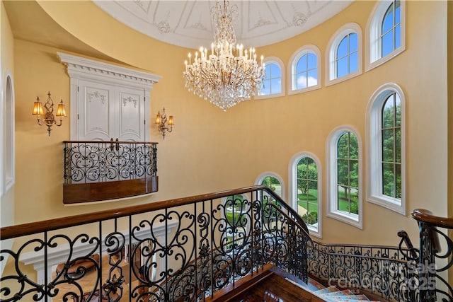 stairs with a high ceiling and a notable chandelier