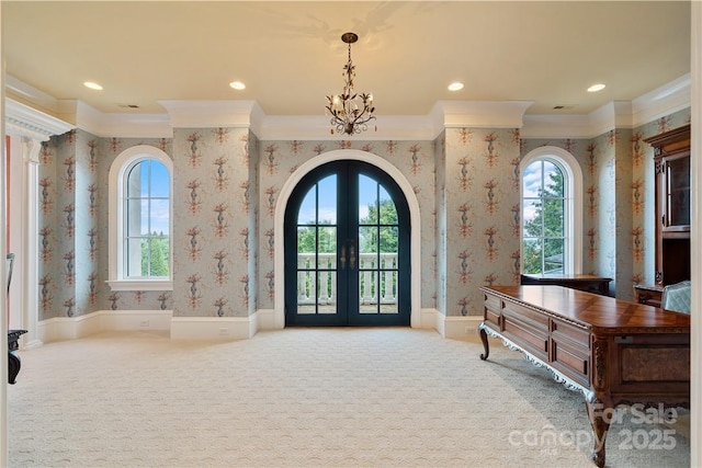 entryway with light carpet, ornamental molding, french doors, and an inviting chandelier