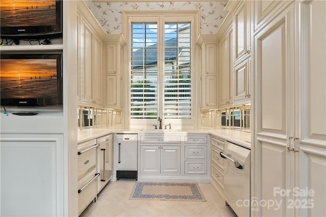 bar with cream cabinetry, plenty of natural light, sink, and light tile patterned floors