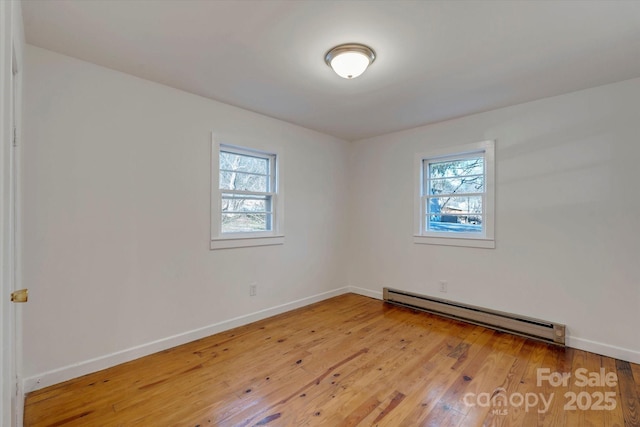 4 Morgan Cove Rd, Candler, NC 28715 - empty room with a baseboard heating unit, a wealth of natural light, and light wood-style flooring