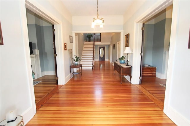 hall with a notable chandelier and light wood-type flooring