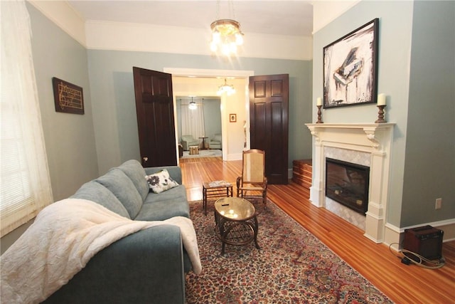 living room featuring crown molding, hardwood / wood-style floors, and a chandelier