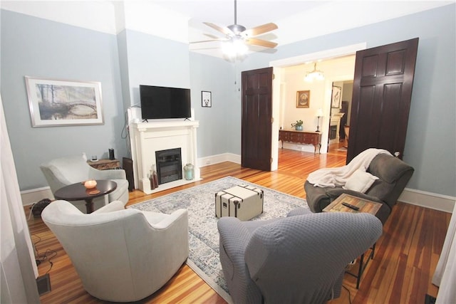 living room with light hardwood / wood-style flooring and ceiling fan with notable chandelier