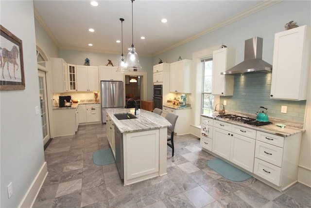 kitchen featuring white cabinetry, wall chimney range hood, and a kitchen island with sink